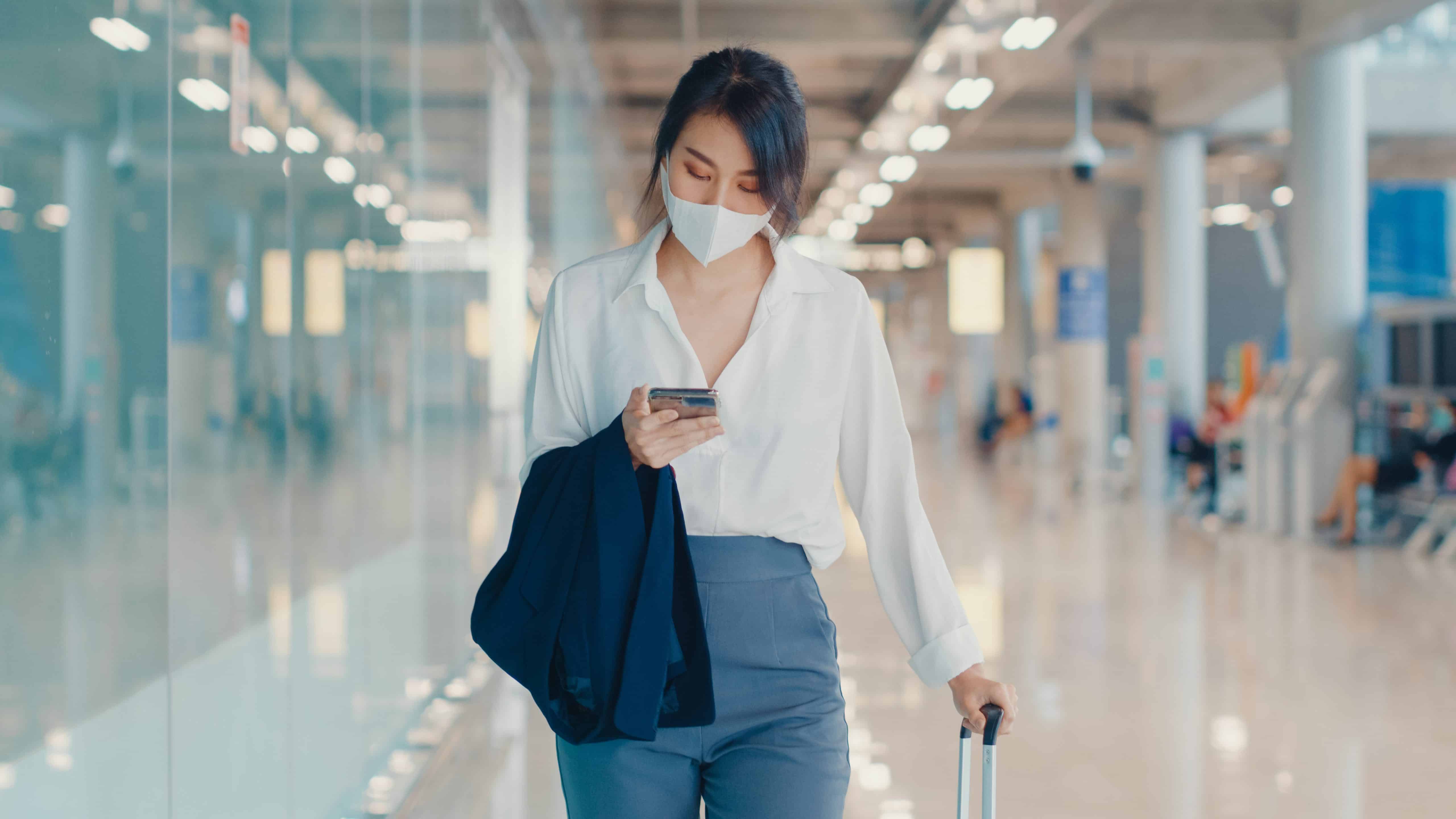 Asian business girl use smart phone for check in boarding pass w