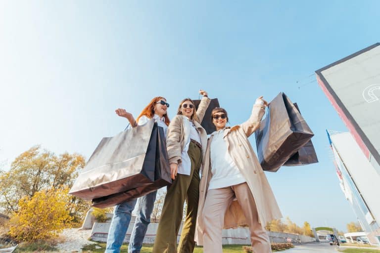 Young women with bags in hands posing for the camera